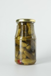 Pickled cucumbers in jar on light background