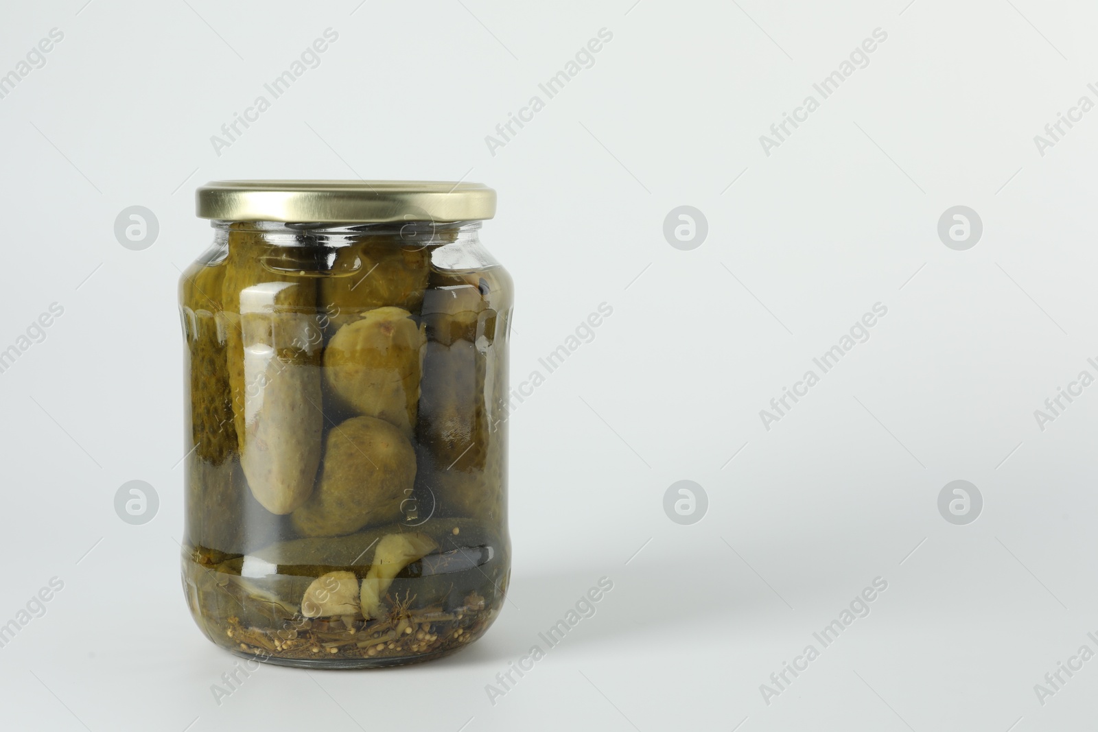 Photo of Pickled cucumbers in jar on light background. Space for text