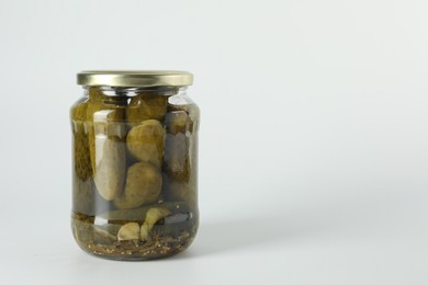 Photo of Pickled cucumbers in jar on light background. Space for text