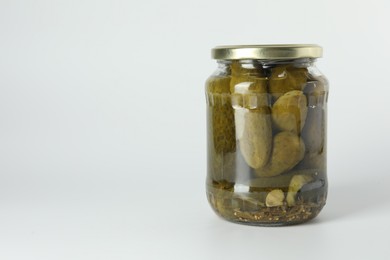 Photo of Pickled cucumbers in jar on light background. Space for text