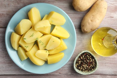 Photo of Tasty potatoes, microgreens, peppercorns and oil on wooden table, top view