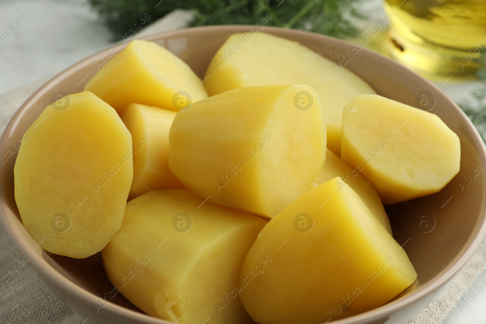 Photo of Boiled potatoes in bowl on table, closeup