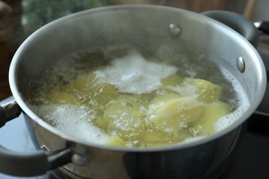 Photo of Boiling potatoes in pot on stove, closeup