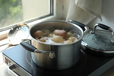 Boiling potatoes in pot on stove in kitchen