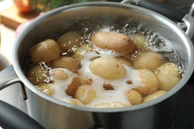 Boiling potatoes in pot on stove, closeup