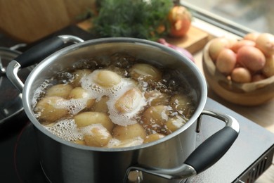 Boiling potatoes in pot on stove in kitchen