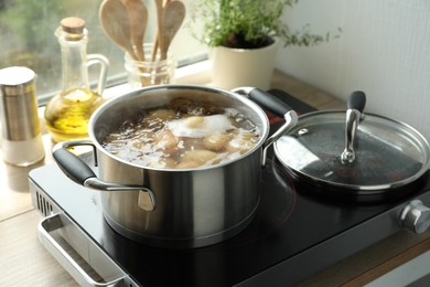 Boiling potatoes in pot on stove in kitchen