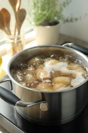 Boiling potatoes in pot on stove in kitchen