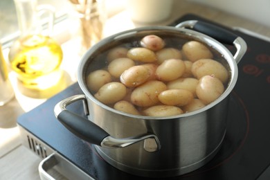 Boiling potatoes in pot on stove in kitchen