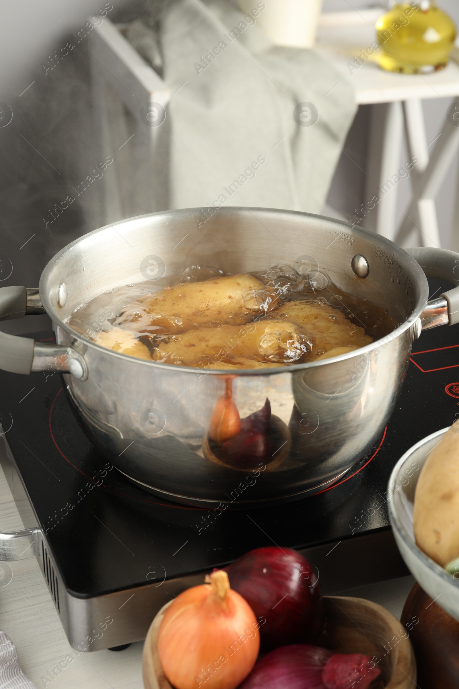 Photo of Boiling potatoes in metal pot on stove