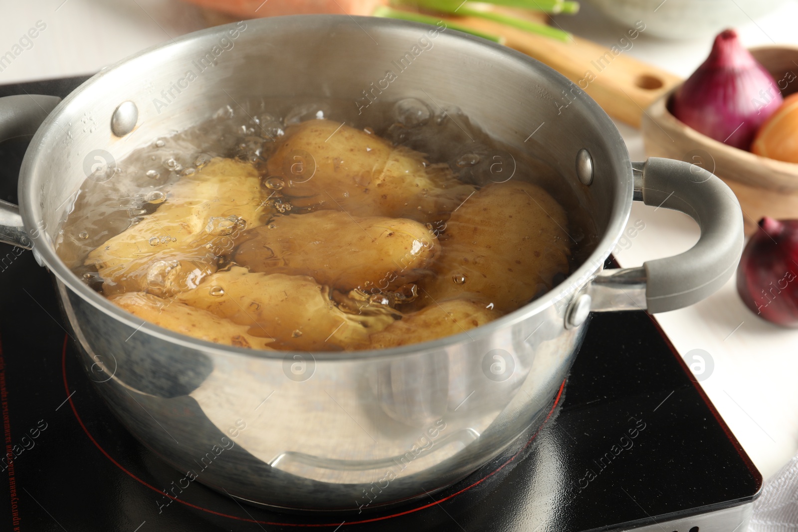 Photo of Boiling potatoes in metal pot on stove, closeup