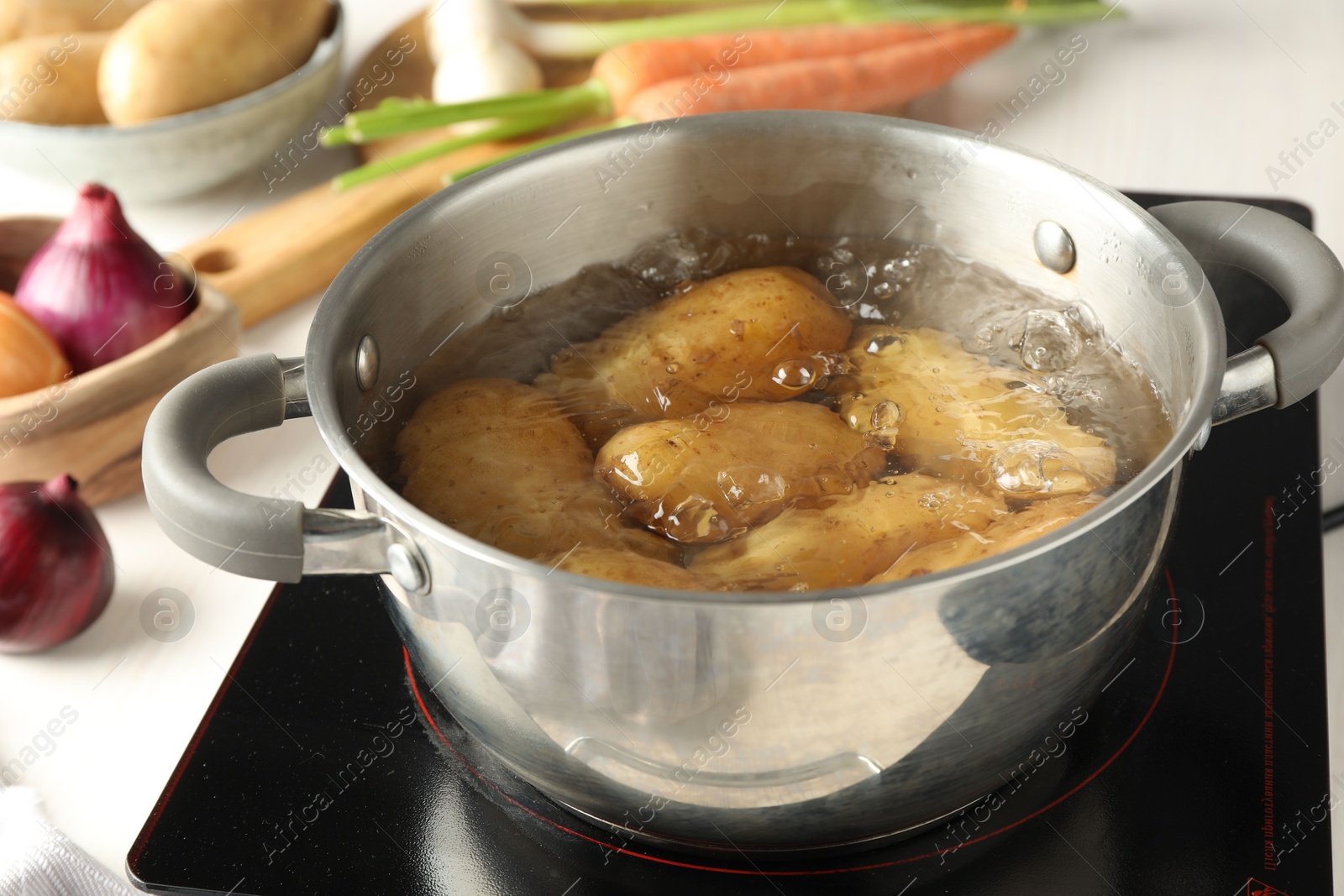 Photo of Boiling potatoes in metal pot on stove