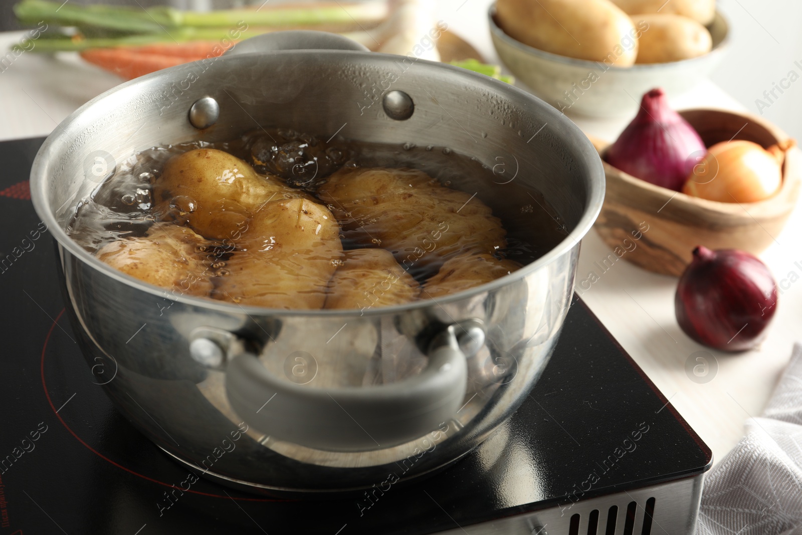 Photo of Boiling potatoes in metal pot on stove