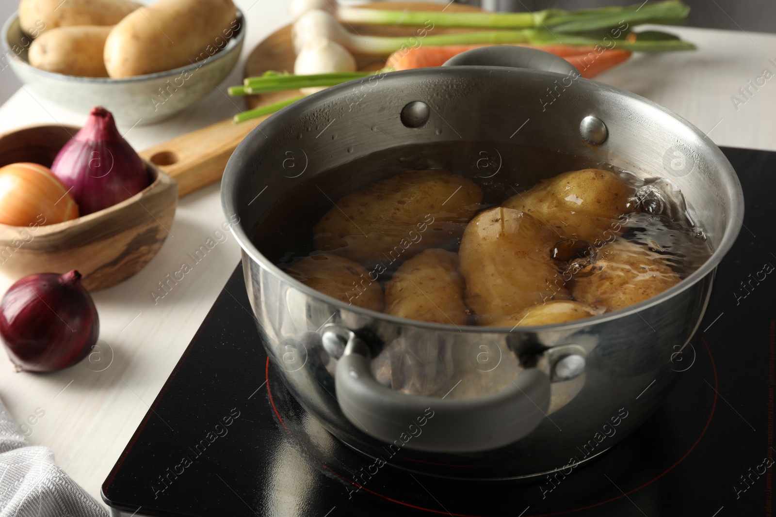 Photo of Boiling potatoes in metal pot on stove