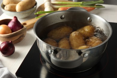 Boiling potatoes in metal pot on stove