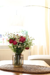 Photo of Beautiful ranunculus flowers and chamomiles in vase on table indoors