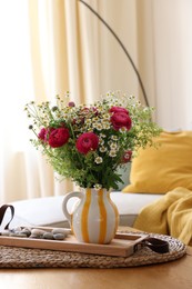 Photo of Beautiful ranunculus flowers and chamomiles in vase on table indoors