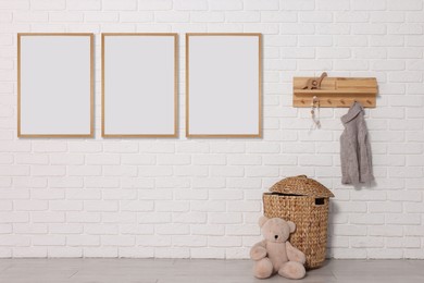 Image of Room for child with blank pictures on white brick wall. Interior design