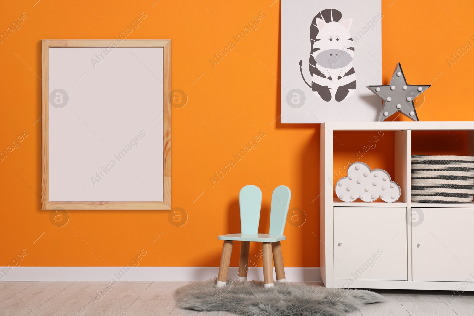 Image of Room for child with empty picture frame on orange wall. Interior design