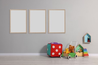 Room for child with blank pictures on grey wall. Interior design