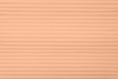 Image of Peach fuzz color textured surface, closeup. Trendy shade of 2024 year