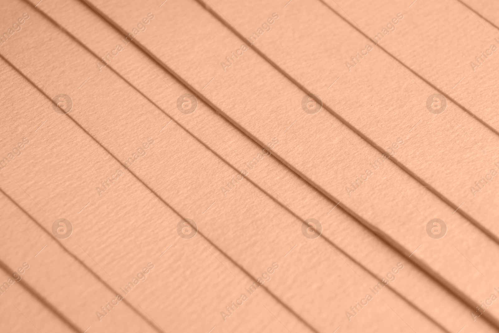 Image of Peach fuzz color paper sheets, closeup. Trendy shade of 2024 year