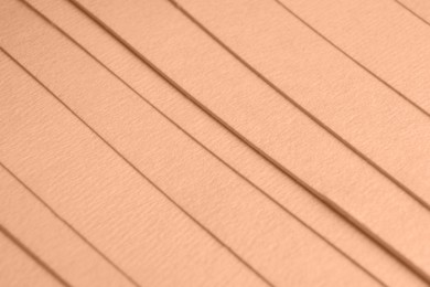 Image of Peach fuzz color paper sheets, closeup. Trendy shade of 2024 year