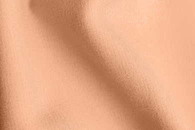 Peach fuzz color fabric, top view. Trendy shade of 2024 year