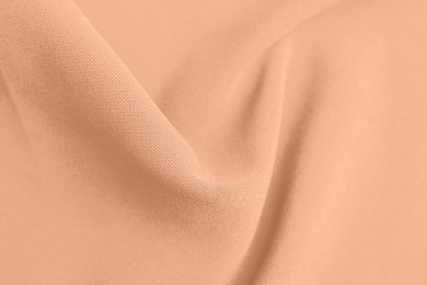 Peach fuzz color fabric, top view. Trendy shade of 2024 year
