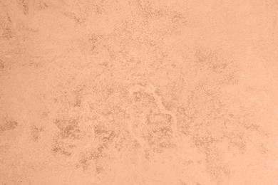 Image of Stone surface of peach fuzz color, top view. Trendy shade of 2024 year