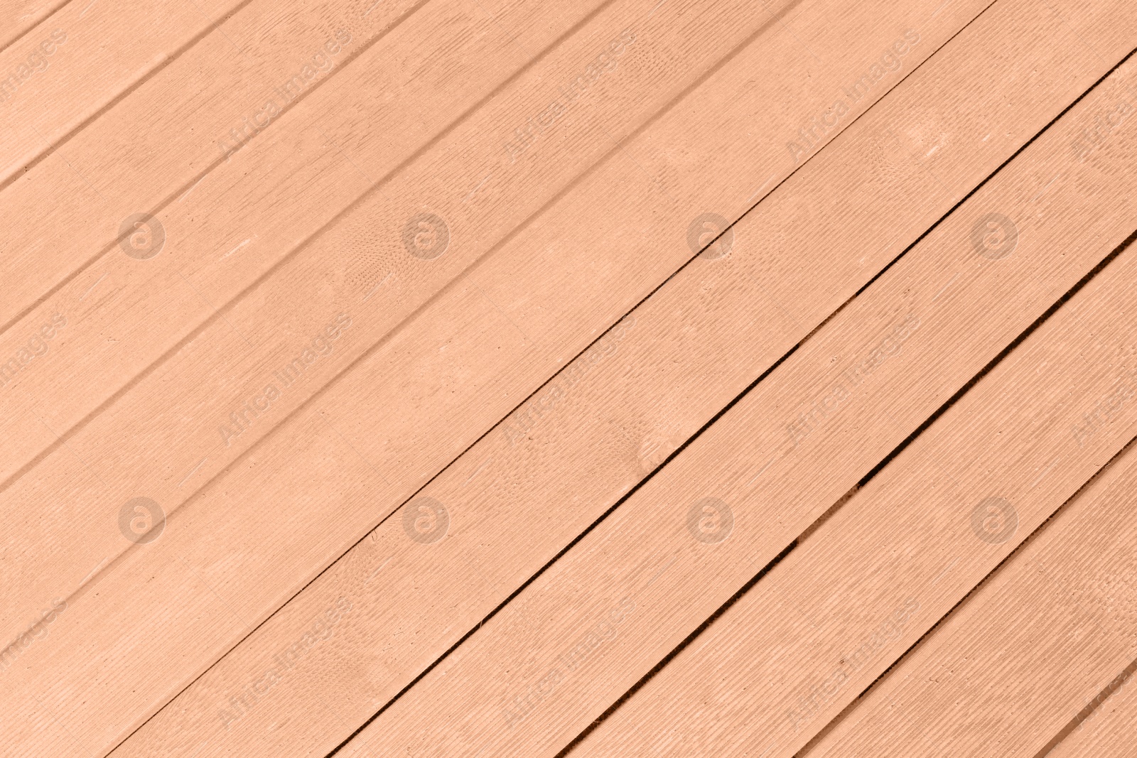 Image of Wooden surface of peach fuzz color, top view. Trendy shade of 2024 year