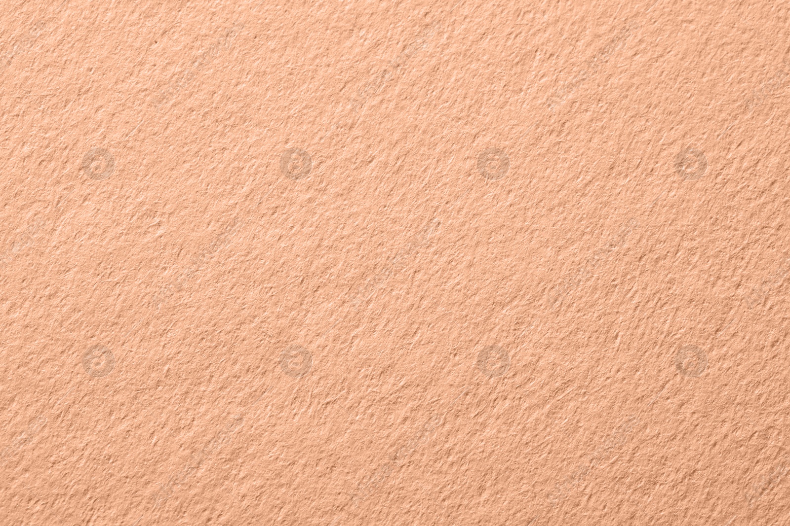 Image of Peach fuzz color paper, closeup. Trendy shade of 2024 year
