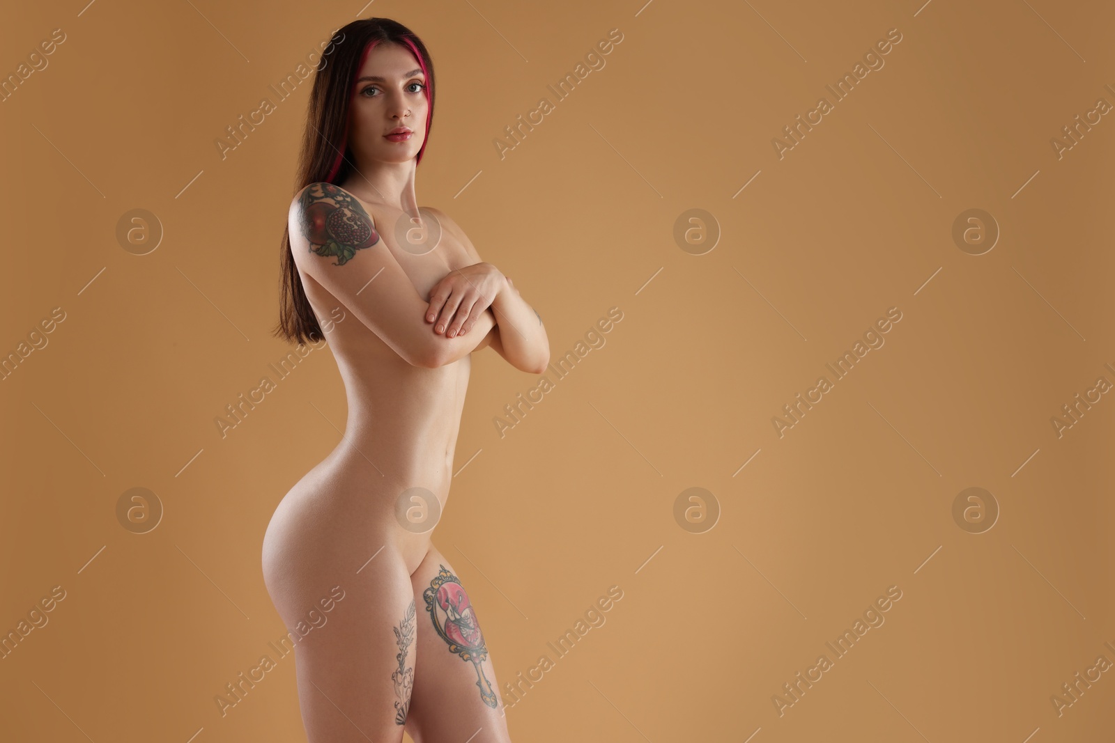 Photo of Sexy nude woman posing on beige background, space for text