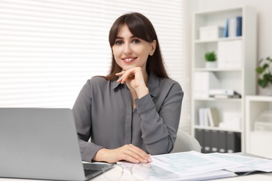 Photo of Portrait of smiling secretary at table in office