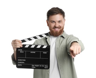 Photo of Making movie. Smiling man with clapperboard pointing at camera on white background