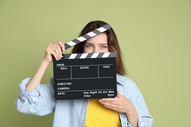 Photo of Making movie. Woman with clapperboard on green background