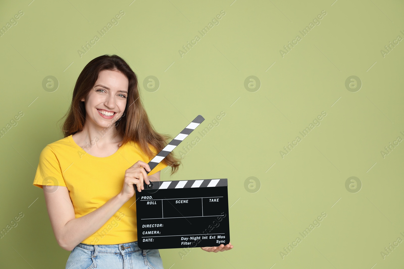 Photo of Making movie. Smiling woman with clapperboard on green background. Space for text