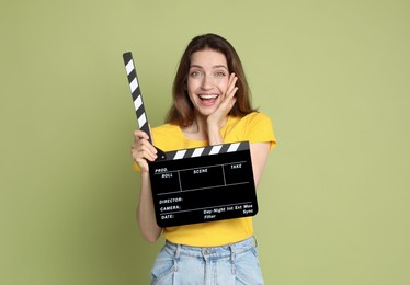 Photo of Making movie. Smiling woman with clapperboard on green background