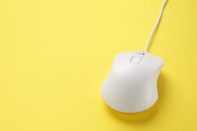 Photo of One wired mouse on yellow background, closeup. Space for text