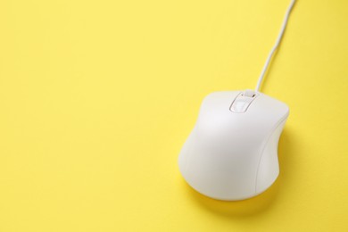 One wired mouse on yellow background, closeup. Space for text