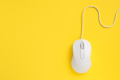 One wired mouse on yellow background, top view. Space for text