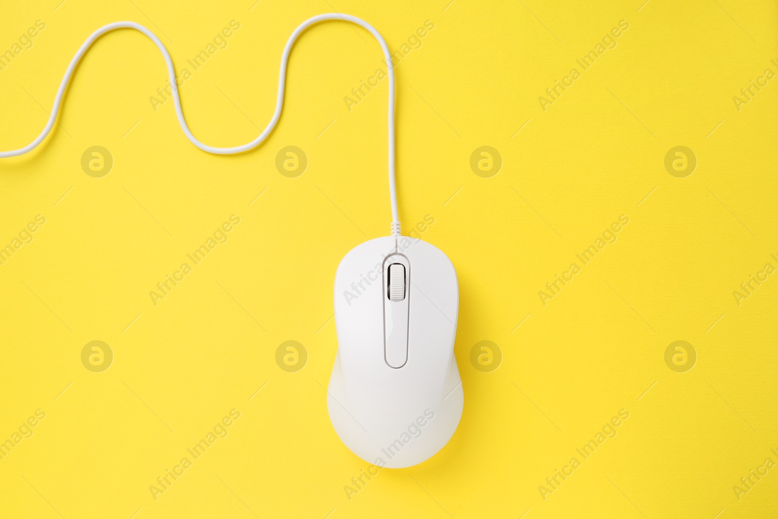 Photo of One wired mouse on yellow background, top view