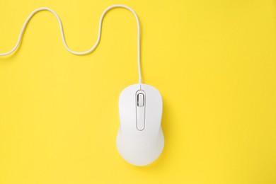 One wired mouse on yellow background, top view