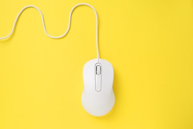 Photo of One wired mouse on yellow background, top view