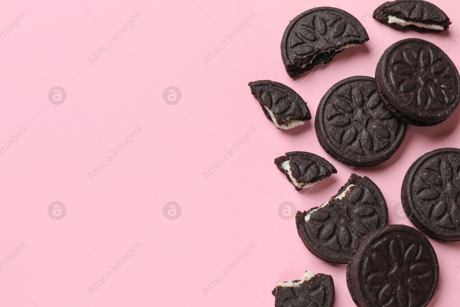 Photo of Tasty sweet sandwich cookies on pink background, flat lay. Space for text