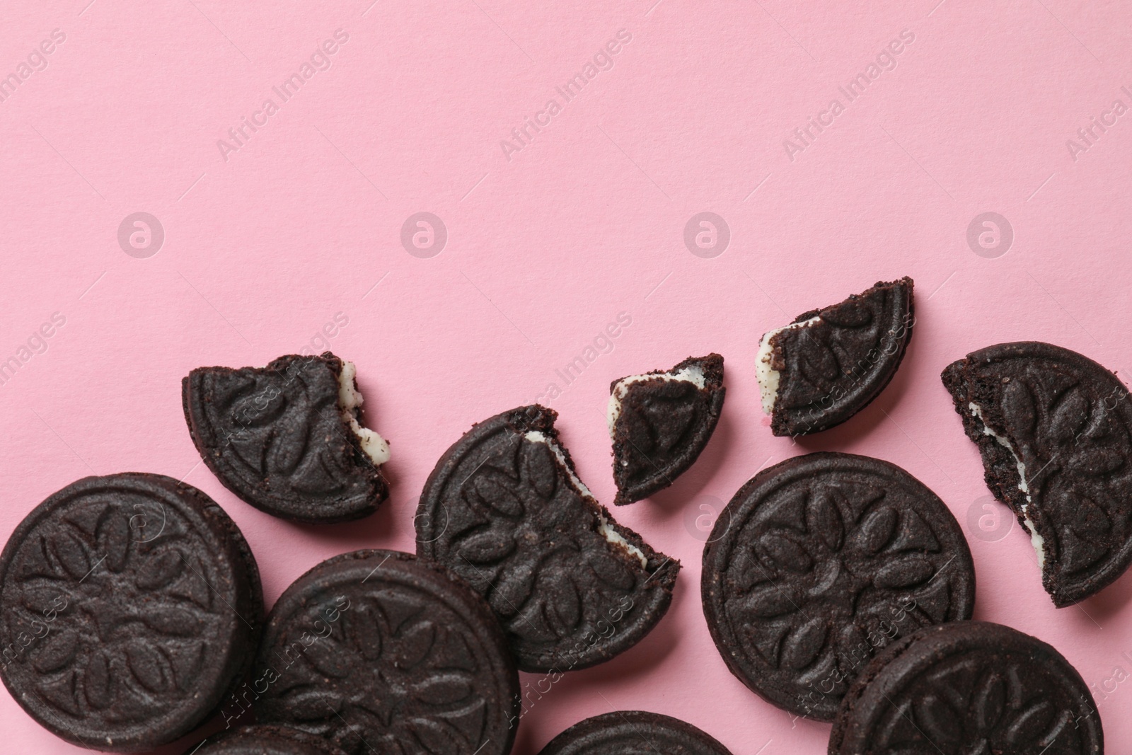 Photo of Tasty sweet sandwich cookies on pink background, flat lay. Space for text