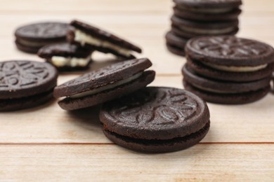 Tasty sandwich cookies on light wooden table, closeup