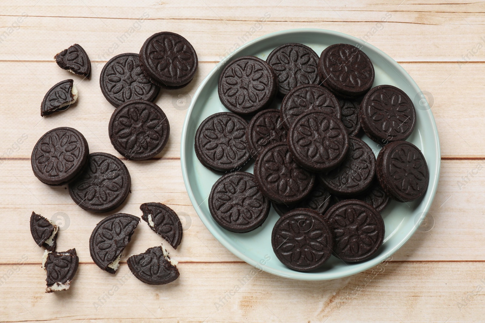 Photo of Tasty sandwich cookies on light wooden table, flat lay