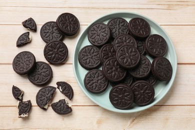 Tasty sandwich cookies on light wooden table, flat lay