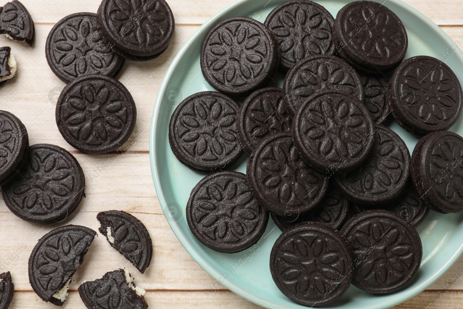 Photo of Tasty sandwich cookies on light wooden table, flat lay